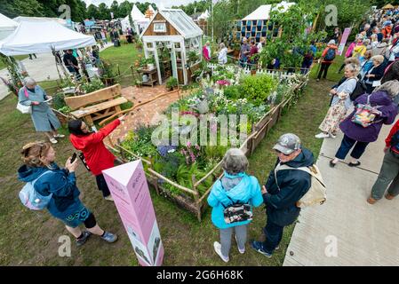 London, Großbritannien. 6. Juli 2021. Besucher sehen den Down Memory Lane Garden des Blue Diamond Design Teams beim neu terminierte RHS Hampton Court Palace Garden Festival, das für die Öffentlichkeit geöffnet wurde. Die größte Blumenschau der Welt wurde 2020 aufgrund der anhaltenden Coronavirus-Pandemie abgesagt und umfasst Gärten von inspirierenden Designern, Promi-Talks, Demonstrationen und Workshops. Besucher der Show müssen die Covid-19-Protokolle beachten. Kredit: Stephen Chung / Alamy Live Nachrichten Stockfoto