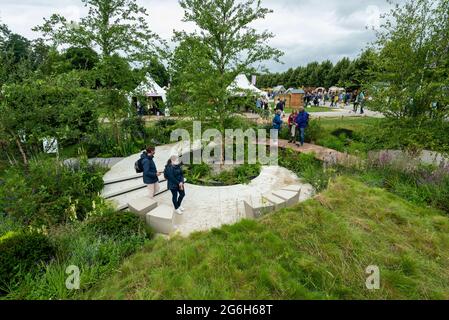 London, Großbritannien. 6. Juli 2021. Besucher sehen den Legacy Garden von Tom Simpson für Cancer Research UK beim neu terminierte RHS Hampton Court Palace Garden Festival, das für die Öffentlichkeit geöffnet wurde. Die größte Blumenschau der Welt wurde 2020 aufgrund der anhaltenden Coronavirus-Pandemie abgesagt und umfasst Gärten von inspirierenden Designern, Promi-Talks, Demonstrationen und Workshops. Besucher der Show müssen die Covid-19-Protokolle beachten. Kredit: Stephen Chung / Alamy Live Nachrichten Stockfoto