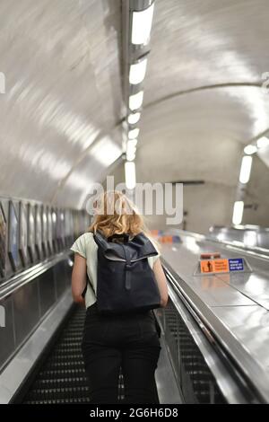 Frauen mit Rucksack, die auf einer Rolltreppe in der londoner U-Bahn unterwegs sind Stockfoto