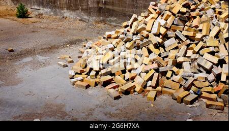 Stapel alter Ziegelsteine auf dem Boden in städtischer Umgebung Baugebäude reißen ab Stockfoto