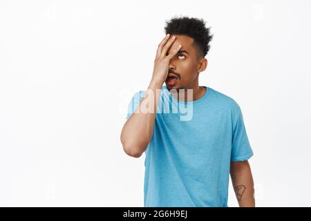 Echte Menschen. Porträt eines verärgerten afroamerikanischen Typen Rollen die Augen, macht Gesichtshandfläche durch Smeth dumm gestört, irritiert, im T-Shirt stehend Stockfoto
