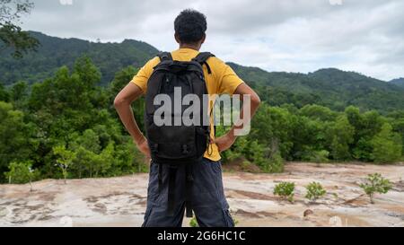 Junger Reisender Mann mit Rucksack stehend entspannen Sie sich gegen Landschaft Landschaft Berggipfel in phuket thailand. Stockfoto