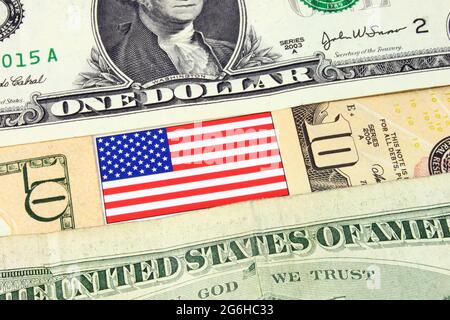 Eine Nahaufnahme der Banknoten amerikanischer Währungen und der Stars & Stripes-Flagge. Stockfoto