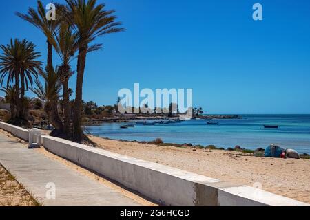 Ein schöner Blick auf die Mittelmeerküste mit Birkenwasser, einem Strand mit weißem Sand und einer grünen Palme. Stockfoto