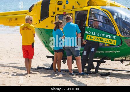 RNLI Rettungsschwimmer mit Hampshire & Isle of Wight Air Ambulance landete im Juli am Strand von Alum Chine, um an einem medizinischen Zwischenfall in Bournemouth, Dorset, Großbritannien, teilzunehmen Stockfoto