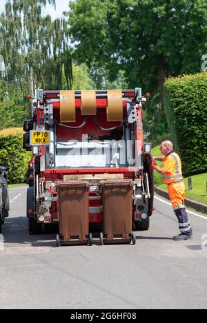 Hampshire, England, Großbritannien. 2021. Auftragnehmer beladen Wheelie Behälter mit Gartenabfall in einen LKW und für die Kompostierung genommen. Stockfoto
