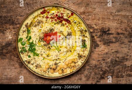 Hummus-Dipping-Sauce aus Kichererbsen, Sesam und anderen Zutaten, die traditionell in der mediterranen und mittleren Osterküche verwendet wird, wird in einer Schüssel serviert Stockfoto