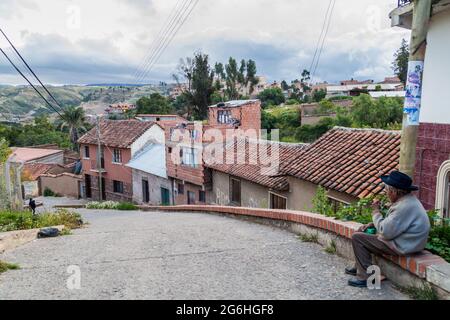 SUCRE, BOLIVIEN - 21. APRIL 2015: Ein Einheimischer sitzt auf einer Straße in Sucre, Bolivien Stockfoto