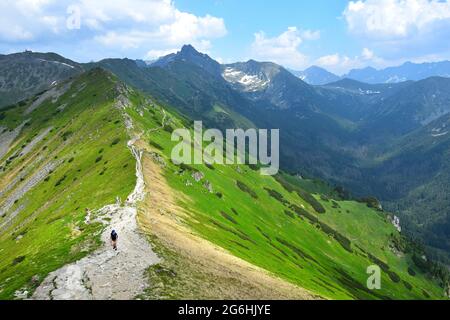 Der Weg vom Berg Kasprov führt entlang der polnisch-slowakischen Grenze. Einige Wanderer auf dem Weg. Hohe Tatra, Polen. Stockfoto