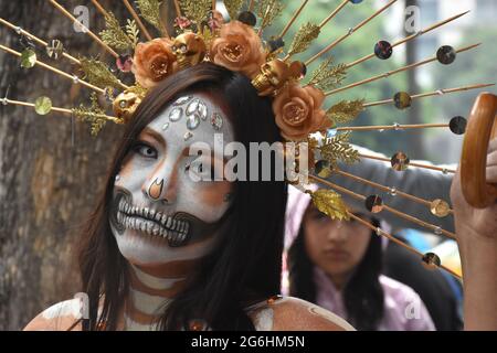 Die Menschen kleiden sich als Catrina, ein ikonisches Bild für den Tag der Toten in Mexiko, und nehmen an einer Parade in der Woche vor dem Tag der Toten Teil. Stockfoto