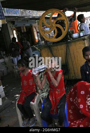 Beawar, Indien. Juli 2021. Ein Mädchen, das an einem heißen Sommertag in Beawar Wasser in einem Zuckerrohrsaft-Laden auf einem Markt trinkt. (Foto: Sumit Saleswat/Pacific Press) Quelle: Pacific Press Media Production Corp./Alamy Live News Stockfoto