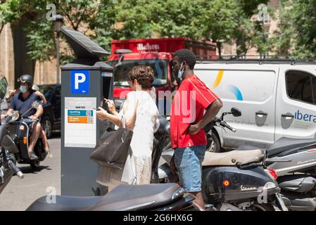 Valencia, Spanien. Juli 2021. Personen, die den neuen Parkuhr verwenden. Valencia integriert die neuen Parkuhren und verlängert die Abholzeiten bis 9:00 Uhr, einschließlich der zuvor nicht bezahlten Stunden von 2:00 bis 4:00 Uhr. Kredit: SOPA Images Limited/Alamy Live Nachrichten Stockfoto