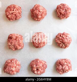 High Angle view Raw Fleischbällchen auf Wachspapier, die zum Würzen und Kochen bereit sind Stockfoto