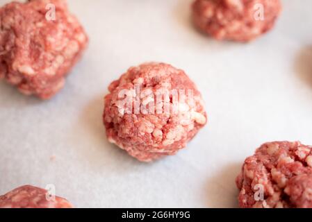 Nahaufnahme einer Reihe von Fleischbällchen. Der Fokus liegt auf einem bestimmten Fleischball Stockfoto