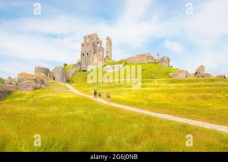 Corfe Castle, Großbritannien - 24 2021. Juni: Touristen besuchen die mittelalterlichen Burgruinen von Corfe Castle, Dorset, England an einem sonnigen Sommertag. Stockfoto