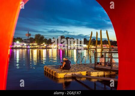 Wien, Wien: Sonnenuntergang im Erholungsgebiet Copa Beach an der Neuen Donau, Schriftskulptur 'Copa Beach', Blick auf die versunkene Stadt 22. Donaust Stockfoto