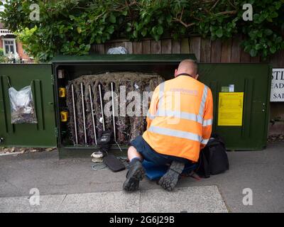 BT OpenReach Telekommunikationstechniker, der in einem Schaltschrank auf der Londoner Straße sah, Stockfoto
