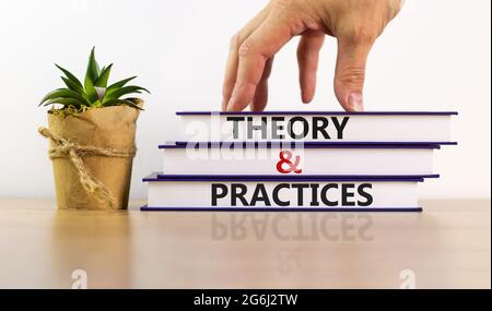 Symbol für Theorie und Praxis. Bücher mit den Worten 'Theorie und Praxis'. Schöner Holztisch, weißer Hintergrund. Wirtschaft und Theorie und Praxis konz Stockfoto