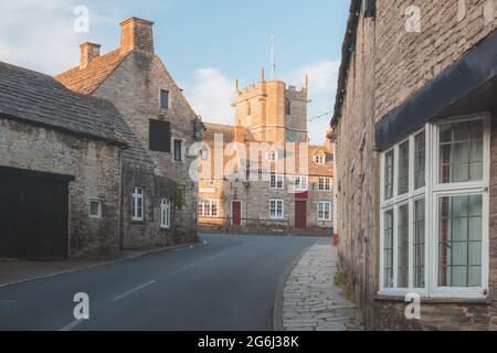 Malerisches, historisches mittelalterliches Dorf von Corfe Castle, Dorset, England mit goldener Stunde Sonnenuntergang oder Sonnenaufgang Sommerlicht. Stockfoto