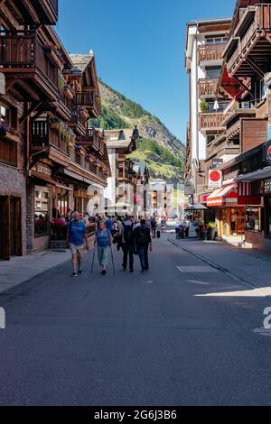 Touristen bummeln in der Hauptstraße von Zermatt, Schweiz Stockfoto
