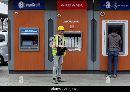 Bauarbeiter vor den Geldautomaten YapiKredi, Akbank, Isbank Bank, nachdem er den monatlichen Gehaltsscheck zurückgezogen hatte. Karakoy, Istanbul - Türkei. Stockfoto