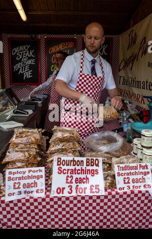London, Großbritannien. 6. Juli 2021. Ein Arbeiter säcke traditionelle Schweinekratzer, um Besucher zu verführen, während das neu terminierte RHS Hampton Court Palace Garden Festival für die Öffentlichkeit geöffnet wird. Die größte Blumenschau der Welt wurde 2020 aufgrund der anhaltenden Coronavirus-Pandemie abgesagt und umfasst Gärten von inspirierenden Designern, Promi-Talks, Demonstrationen und Workshops. Besucher der Show müssen die Covid-19-Protokolle beachten. Kredit: Stephen Chung / Alamy Live Nachrichten Stockfoto