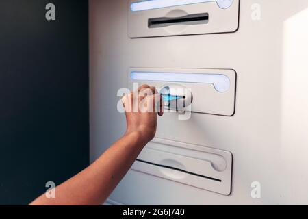 Hand einer nicht erkennbaren afrikanischen Frau, die ihre Kreditkarte auf einen Geldautomaten legt Stockfoto