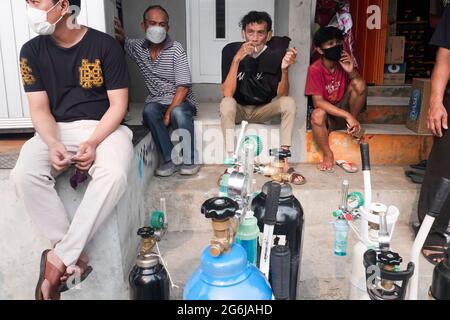 Jakarta, Indonesien. Juli 2021. An einer Tankstelle in Jakarta sitzen Menschen, die warten, bis sie an der Reihe sind, um ihre Sauerstofftanks aufzufüllen. Indonesien steht vor einer Sauerstoffkrise angesichts einer Zunahme der Covid-19-Fälle. Am 4. Juli kündigte die indonesische Regierung 2,284,084 bestätigte Fälle von COVID-19 in allen 34 Provinzen Indonesiens an, mit 295,228 aktiven Fällen und 60,582 Todesfällen. Kredit: SOPA Images Limited/Alamy Live Nachrichten Stockfoto