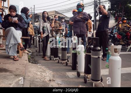 Jakarta, Indonesien. Juli 2021. An einer Tankstelle in Jakarta warten Menschen in der Schlange, um ihre Sauerstofftanks aufzufüllen. Indonesien steht vor einer Sauerstoffkrise angesichts einer Zunahme der Covid-19-Fälle. Am 4. Juli kündigte die indonesische Regierung 2,284,084 bestätigte Fälle von COVID-19 in allen 34 Provinzen Indonesiens an, mit 295,228 aktiven Fällen und 60,582 Todesfällen. Kredit: SOPA Images Limited/Alamy Live Nachrichten Stockfoto