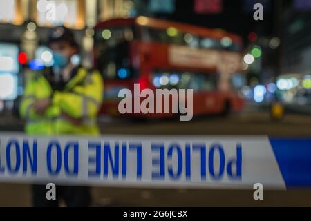 Ein Polizeibeamter steht im Umkreis eines Tatortes im Londoner Oxford Circus. Stockfoto