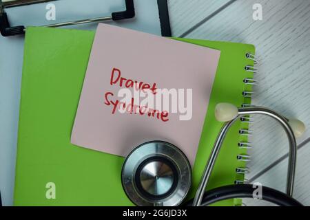 Dravet-Syndrom Schreiben Sie auf klebrige Notizen isoliert auf Holztisch. Stockfoto