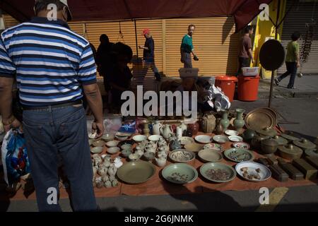 Ein Mann, der beim Gaya Sunday Market in der Gaya Street, Kota Kinabalu, Sabah, Malaysia, auf Porzellan achtet. Stockfoto