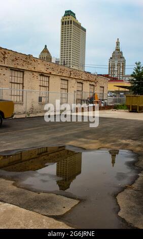 Die Skyline von Tulsa Oklahoma USA spiegelt sich in einer Pfütze auf einem Parkplatz wider Stockfoto