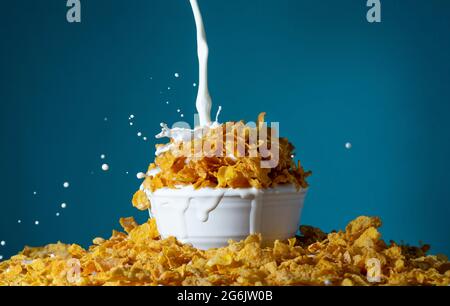 Eine Schüssel mit gesunden Maisflocken mit spritzender Milch zum Frühstück Stockfoto