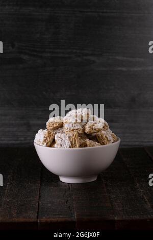 Weiße Schale mit Frühstückszerealien auf einem Holztisch Stockfoto