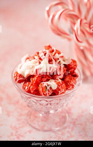 Zuckerrohr Weiße Schokolade Nieselter roter Popcorn auf einem rosafarbenen Tisch Stockfoto