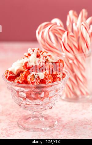 Zuckerrohr Weiße Schokolade Nieselter roter Popcorn auf einem rosafarbenen Tisch Stockfoto