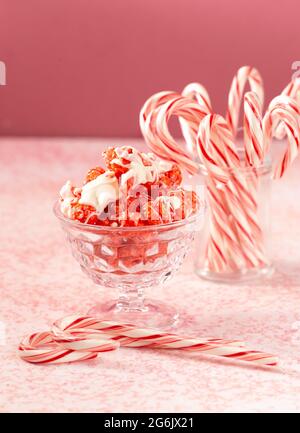 Zuckerrohr Weiße Schokolade Nieselter roter Popcorn auf einem rosafarbenen Tisch Stockfoto