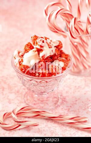 Zuckerrohr Weiße Schokolade Nieselter roter Popcorn auf einem rosafarbenen Tisch Stockfoto