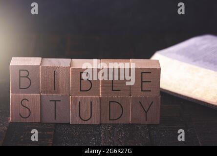 Bibelstudium in Blockbuchstaben auf einem Holztisch mit einer Bibel geschrieben Stockfoto