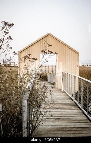 Holzsteg, der sich bis in die Feuchtgebiete am Rande der Bucht von San Francisco erstreckt. Open-Gate-Struktur beliebt für Instagram Posen. Stockfoto