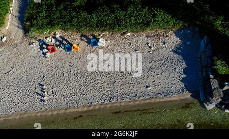 Luftaufnahme von oben einer Gruppe von farbenfrohen Adirondack-Stühlen an einem Strand bei Sonnenuntergang in Door County, Egg Harbor, Wisconsin, USA Stockfoto