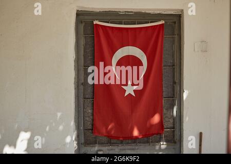 Alte türkische Provinz mit altem Haus und großer türkischer Flagge an sonnigen Tagen. Hochwertige Fotos Stockfoto