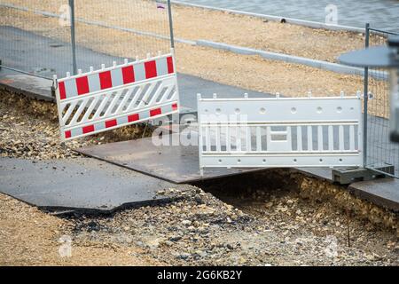 Die Straße wird erneuert, die Bauarbeiten laufen. Hindernisse behindern die Fußgänger und Autofahrer. Der Bürgersteig ist aufgerissen, Steine und Schmutz Stockfoto