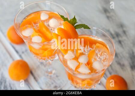 Sommer Getränke, Rosmarin aprcot Cocktails mit Eis im Glas. Erfrischende Sommer hausgemachte alkoholische oder alkoholfreie cocktailsor Detox infundiert aromatisiert Stockfoto