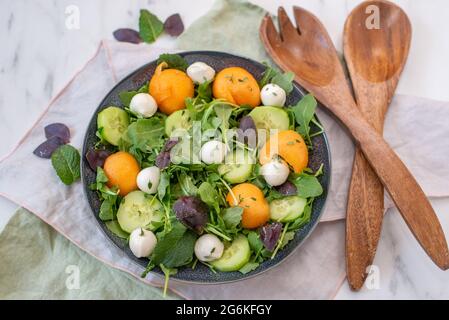 Frischer Sommersalat mit Rucola, Mozzarella und Melone Stockfoto