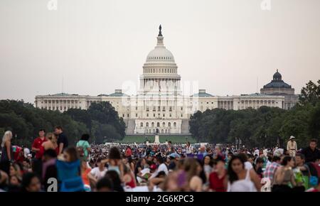 Ein Blick auf das Kapitolgebäude in Washington, DC, während des 4. Juli (2021) Besucher auf das Feuerwerk über der National Mall warten. Stockfoto