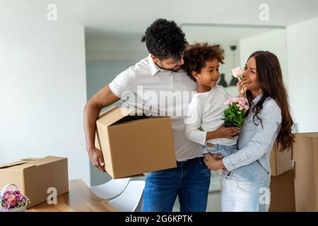 Elternteil Kind Umzug Liebe Spaß Konzept. Glückliche multiethnische Familie zieht in neue Heimat Stockfoto