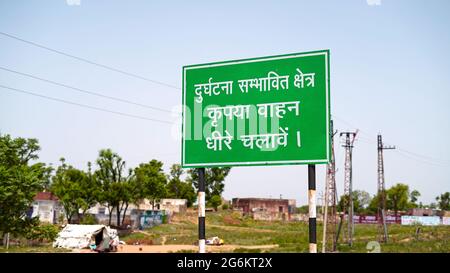 Warnschild mit Hindi-Sprache. Straßenschild an bewusst Menschen langsam in besiedelten Bereich zu gehen. Stockfoto