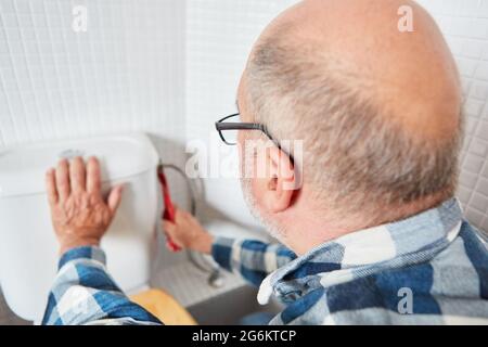 Klempner oder Heimwerker reparieren oder installieren Toilettenzisterne in der Toilette Stockfoto